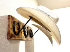 a cowboy hat hanging on the side of a wall