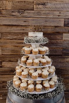 a three tiered cake with cupcakes on top