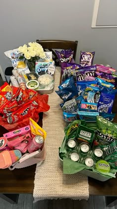 the table is covered with many different types of snacks and condiments on it