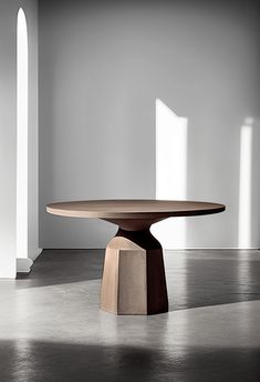 a round table sitting on top of a cement floor next to two tall white pillars