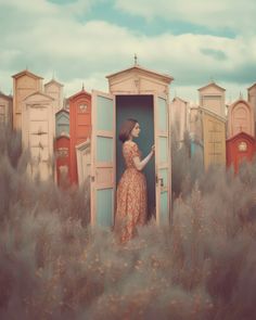 a woman is standing in the doorway of a row of beach huts with doors open