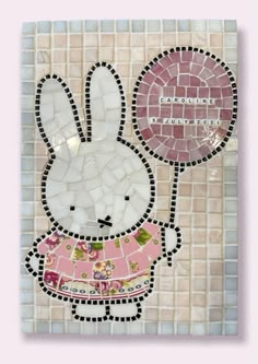 a mosaic tile wall with a bunny holding a balloon