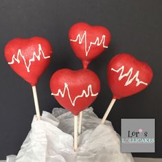 three red heart shaped lollipops with white writing on them