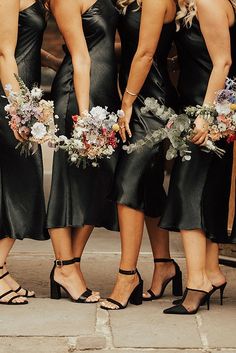 the bridesmaids are wearing black dresses and holding bouquets