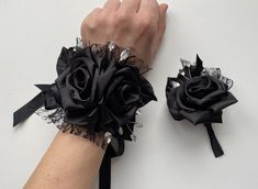 two wrist corsages with black roses and crystal stones on each one, the other hand