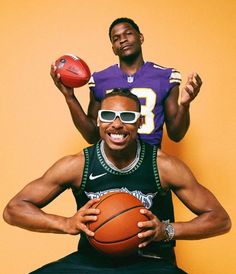 a man sitting on top of another man holding a basketball