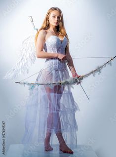 a woman dressed as an angel holding a bow and arrow