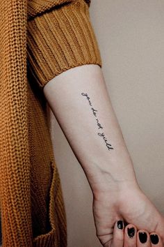 a woman's arm with a small tattoo on it