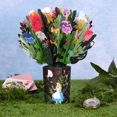 there is a vase with flowers in it on the grass next to a coin bank