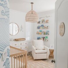 a baby's room with a crib, chair and wall hangings on the walls