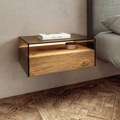 a nightstand with a book on it next to a bed