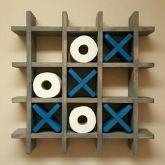 two rolls of toilet paper sitting on top of a wooden shelf with blue crosses painted on it