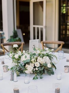 the table is set with white flowers and candles for an elegant wedding reception in charleston, sc