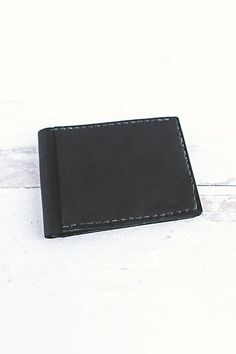 Our newest bifold leather wallet, handmade in our studio, features four card slots (two inside, two outside) and a billfold pocket. This slim design can fit up to 10+ cards and cash comfortably. This durable buffalo calf leather has a smooth finish and will gradually darken and patina beautifully overtime. **Contents** * 100% Genuine Korba Buffalo Calf Leather * Vegetable Tanned * 4 card slots + billfold pocket * Handmade **Care/Import** * Made in the USA **Dimensions** * Measures approximately Minimalist Leather Bifold Wallet, Classic Handmade Black Wallet, Classic Black Handmade Wallet, Bracelets Leather, Green Brands, Leather Bifold Wallet, Natural Tan, Bifold Wallet, Slim Design