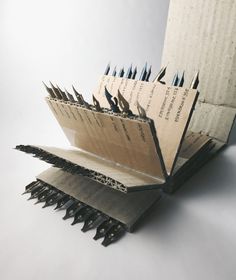 an open book with several pages cut out and stacked on top of each other, in front of a white background