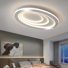 a bed room with a neatly made bed and a round light above the headboard