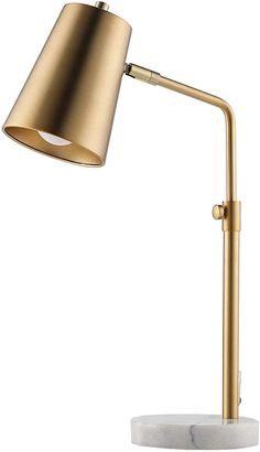 a gold desk lamp with a marble base on a white background, the light is turned on