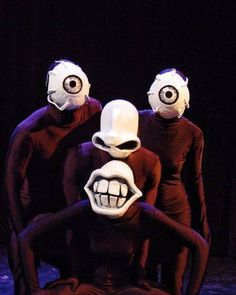 three people with masks on their faces and mouths are sitting in front of each other