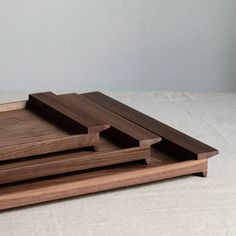 two wooden trays sitting on top of each other