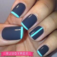 a woman's hand with blue and black nail polishes on her nails,