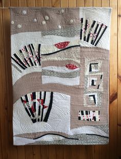 a quilted wall hanging on the side of a wooden wall