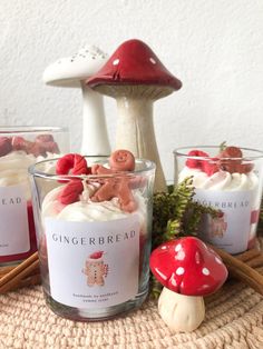 three candles are sitting on a table with mushrooms and other items around them in glass cups