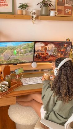 a woman sitting at a desk with two computer monitors and a keyboard in front of her