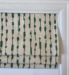 a close up of a window with a green and white curtain on it's side