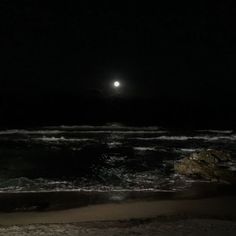 the moon is shining over the ocean at night