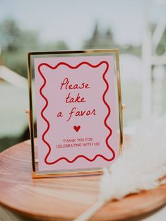 a pink sign that says please son our guest book on top of a wooden table