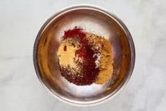 a metal bowl filled with spices on top of a white counter