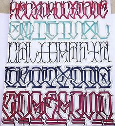 some type of lettering that is on top of a piece of paper with the letters in different colors