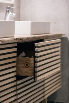 a bathroom vanity with two sinks and wooden slats on the countertop in front of it