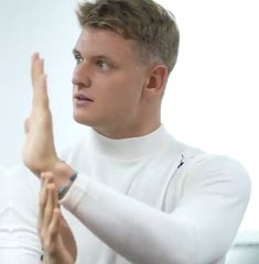 a man in white shirt holding up his hand