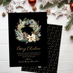 two christmas cards on top of each other with pine cones and holly wreaths in the middle