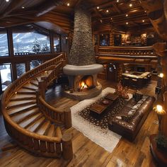 a living room filled with furniture and a fire place next to a spiral stair case