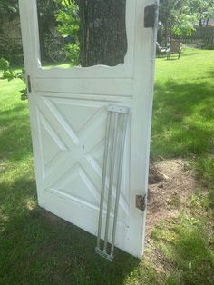 an old white door in the grass near a tree