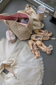 a ballerina's outfit and ballet shoes on the floor next to a window