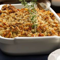 a casserole dish with meat and vegetables in it sitting on a blue table