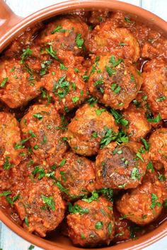 meatballs with tomato sauce and parsley in a bowl