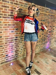 a woman standing in front of a brick wall wearing fishnet stockings and tights