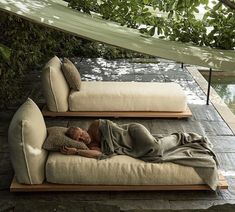 a person laying on top of a couch next to a body of water