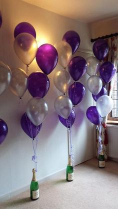 there are many balloons in the room and one has a wine bottle on the floor