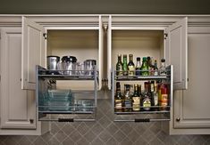 two open cabinets in a kitchen filled with bottles and glasses