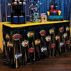 the table is decorated with black, yellow and blue confetti for an awesome birthday party