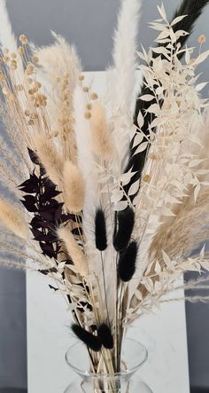 a vase filled with lots of white and black flowers