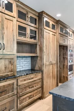 a kitchen with wooden cabinets and marble counter tops