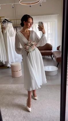 a woman in a white dress taking a selfie