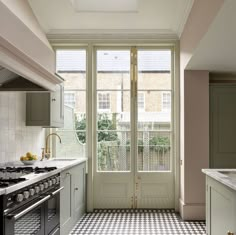 a kitchen with an oven, sink and stove top in front of a large window