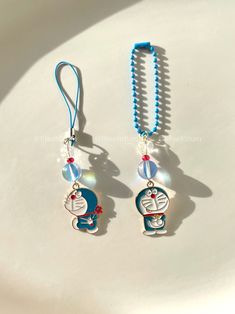 two necklaces on a white plate with a blue beaded cord attached to them